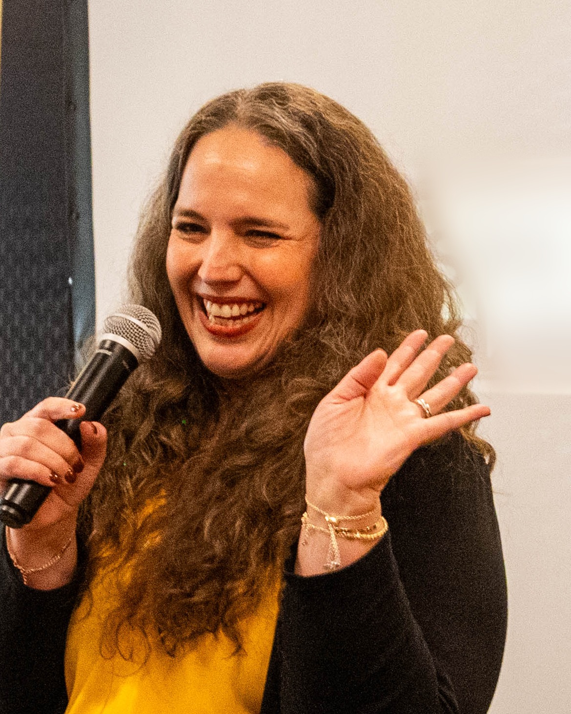Elda Acevedo Estefania laughing while speaking with a microphone